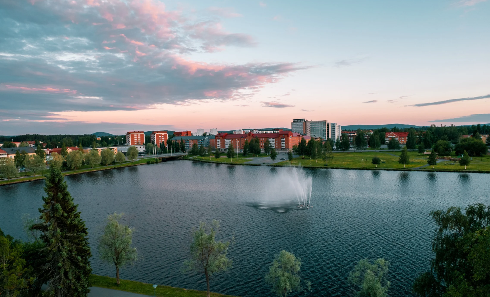 Drönarbild över stad och vatten i kvällsljus